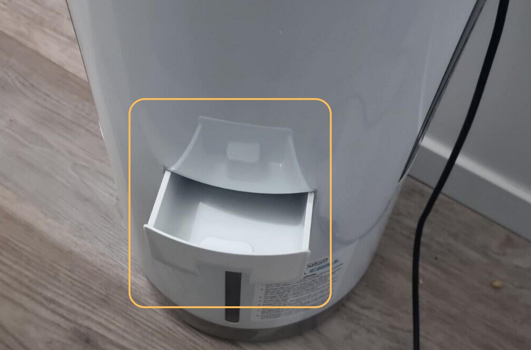 Der Livington InstaChill Luftkühler steht auf dem Boden und das Fach für das Wasser, Eiswürfel und Kühlakkus ist herausgeschoben und markiert.